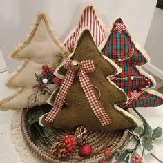 three christmas trees made out of burlocks and plaid ribbon sit in a basket