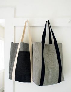 two totes hanging from hooks on the wall