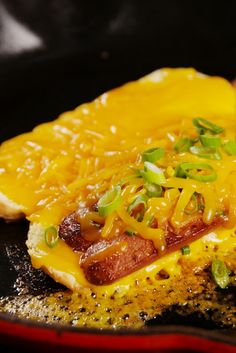 a frying pan with some food inside of it and a spoon in the skillet