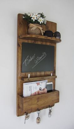 a wooden shelf with some books on top of it and a chalkboard attached to the wall