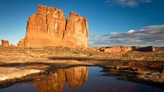 the rock formations are reflected in the still water