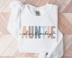 * HOLIDAY ORDER DEADLINE: DEC 9 * (Orders placed after this date may not arrive by Dec 24th.) Personalized Auntie Sweatshirt with Niece Nephew Names Please Note the Following: - A mockup can be sent if requested.  Please add request in the personalization area.  - I can offer custom requests. Please message me before purchasing to inquire. This adult sweatshirt is super soft; size up for a slouchy/oversized look. ITEM OVERVIEW * Gildan 18000 * Unisex crewneck sweatshirt * 50% Cotton, 50% Polyest White Letter Print Sweatshirt For Birthday, White Sweatshirt For Mother's Day, White Sweatshirt With Name Print For Birthday, Aunt Sweatshirt Ideas, Auntie Hoodies, Auntie Sweatshirt With Names, Aunt Sweater, Aunt Sweatshirt, Aunt Birthday Gift