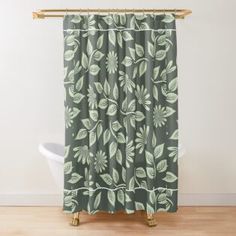 a green and white shower curtain with leaves on the outside, in front of a bathtub