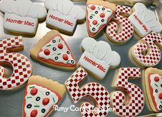 decorated cookies are arranged in the shape of numbers and pizzas on a baking sheet