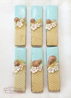 four pieces of cake decorated with seashells and flowers