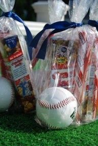 two plastic bags filled with snacks and a baseball on the ground next to each other