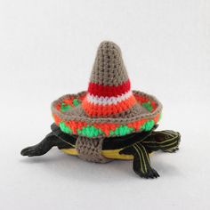 a crocheted mexican hat sitting on top of a tortoise shell in front of a white background