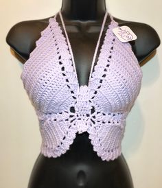 a female mannequin wearing a purple crochet top with a white tag on it