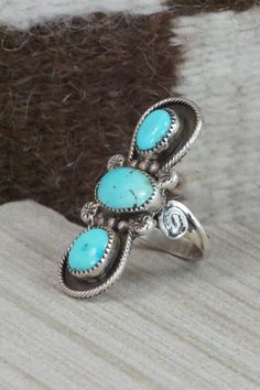 This Kingman turquoise and sterling silver ring was made by Navajo silversmith Priscilla Reeder. The back is signed PR and stamped sterling.Size: 7.5Length: 1 5/8"Width: 7/8"Free shipping on all orders! We ship with USPS and always include tracking. All orders ship within a day of payment.Returns are accepted up to 30 days after you receive your order. Just send us a message. Our shop offers cash back or store credit. The item must be returned in new condition. Collectible Turquoise Cabochon Ring, Sterling Silver Turquoise Ring Collectible, Sterling Silver Turquoise Ring For Collectors, Collectible Sterling Silver Turquoise Ring, Untreated Sterling Silver Turquoise Ring, Vintage Turquoise Ring With Inlay, Blue Hallmarked Turquoise Ring, Vintage Turquoise Inlay Ring, Kingman Turquoise