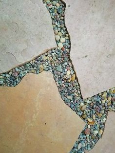 a close up of a tile floor with rocks and gravel on it's side