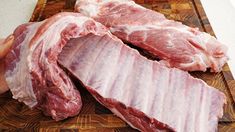 two pieces of raw meat sitting on top of a cutting board