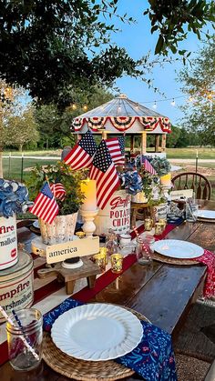 an outdoor table with patriotic decorations and plates