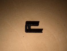 the letter e is made out of wood and has black paint on it's surface