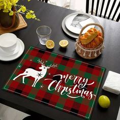 a christmas placemat with the words merry christmas on it next to plates and cups