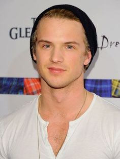 a young man wearing a white shirt and black hat