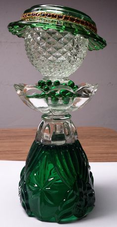 a green glass vase sitting on top of a wooden table