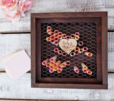 a wooden frame with some crayons in it and a heart on the inside