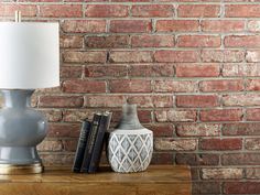 a lamp sitting on top of a wooden table next to a book shelf with books