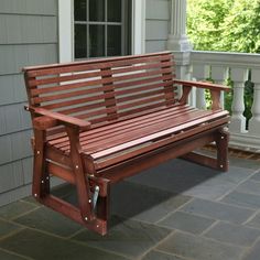 a wooden bench sitting on top of a stone floor next to a door and window