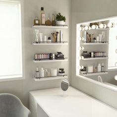 a white desk and chair in a small room with shelves on the wall above it