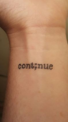 someone has a tattoo on their wrist that says continue