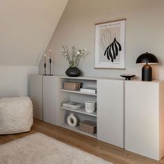 a living room with a book shelf and vases