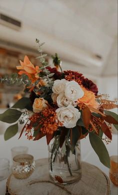 a vase filled with lots of flowers on top of a table