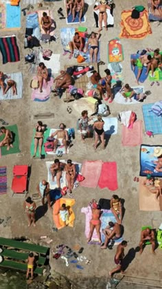 many people are laying on towels at the beach