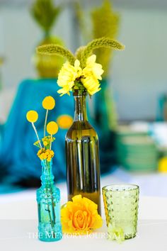 three vases with yellow flowers are sitting on a table