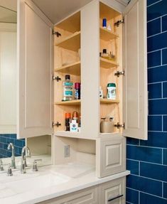 a bathroom with blue tile and white cabinets