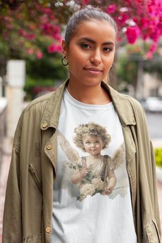 "Remember those \"glossy images\" we used to collect when we were young? This t-shirt has this style of nostalgic design. beautiful vintage angel glossy picture style graphic Unisex Softstyle T-Shirt, cherub, angels, baby gift, pixie, vintage print, floral,  The unisex soft-style t-shirt puts a new spin on casual comfort. Made from very soft materials, this tee is 100% cotton for solid colors. Heather colors and sports grey include polyester. The shoulders have twill tape for improved durability. There are no side seams. The collar is made with ribbed knitting to prevent curling damage.  .: 100% ring-spun cotton (fiber content may vary for different colors) .: Light fabric (4.5 oz/yd² (153 g/m .: Eurofit .: Tear-away label .: Runs true to size" Pixie Bob Cats, Style Graphique, Dragon Mask, Angel Shirt, Nostalgic Design, Layered Fits, Dragons Gift, Vintage Angel, Butterfly Gifts