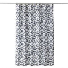 a shower curtain with an intricate pattern on the bottom and side, hanging from a metal rod