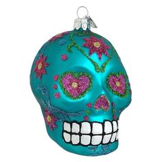 a blue skull ornament with pink flowers on it