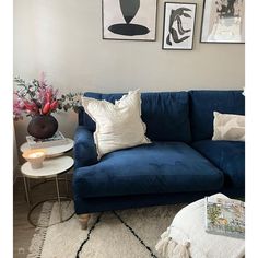 a living room with blue couches and white rugs on the floor in front of pictures