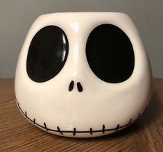 a white and black skull sitting on top of a wooden table