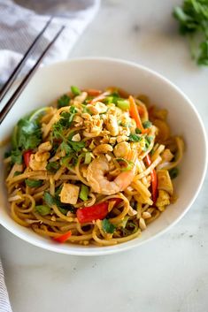 a white bowl filled with noodles and vegetables