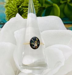 a ring that is sitting on top of a white cloth with flowers in the background