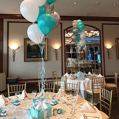 a table set up for a party with blue and white balloons