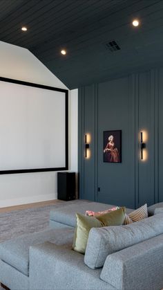 a living room with couches and a flat screen tv on the wall in front of it