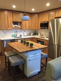 a kitchen with wooden cabinets and stainless steel appliances, including a center island in the middle