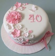 a white cake with pink flowers and butterflies on it