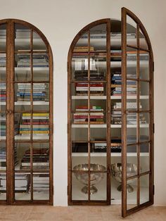 two arched glass doors with bookshelves in the middle and shelves on either side