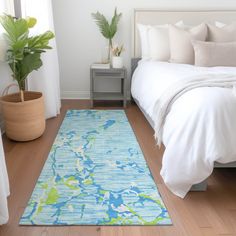 a bedroom with a blue and green rug on the floor next to a white bed