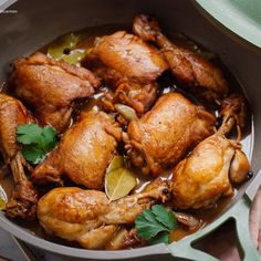 a pan filled with cooked chicken and garnished with cilantro