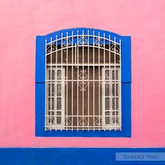 a blue and pink building with a window