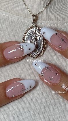 the woman is wearing white and pink nails with silver decorations on it's fingers