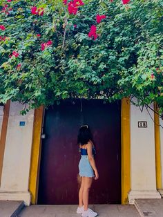 a woman standing in front of a tree with pink flowers