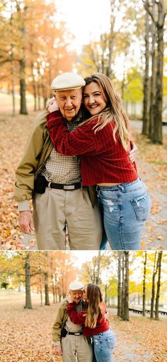 an older man and woman hugging each other in front of trees with leaves on the ground