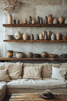 a living room filled with lots of furniture and shelves covered in vases on top of them