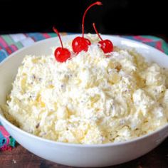 a white bowl filled with cream cheese and cherries